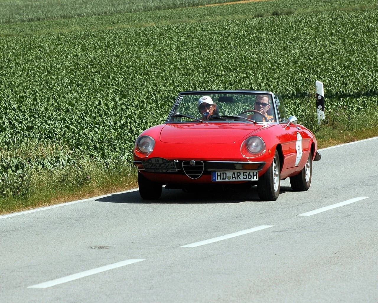 Red Alfa Romeo Spider roadster with the hood down